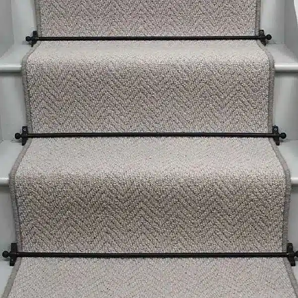 Herringbone Pewter Sisal Stair Runner on a staircase with a black border.