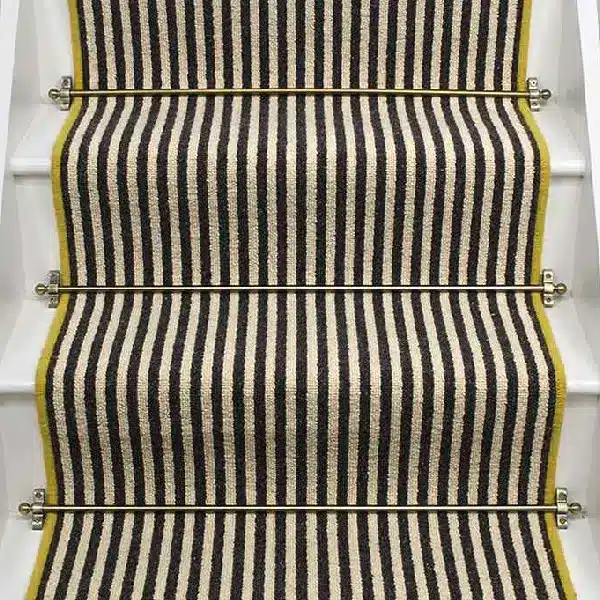 Gatsby wool stair runner with black and beige stripes, yellow edging, and brass stair rods. (2)