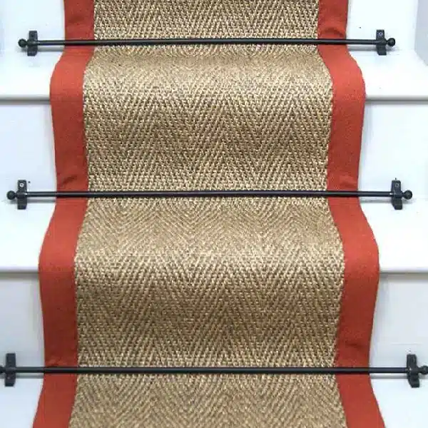 Herringbone Pewter Sisal Stair Runner on a staircase with a black border.