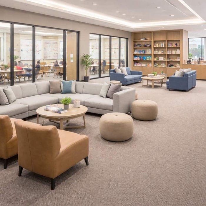 Beige loop pile wall to wall carpet in a spacious office lounge