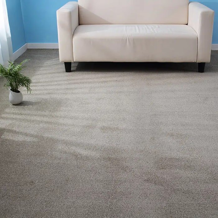 Light grey cut pile wall to wall carpet beneath a white sofa